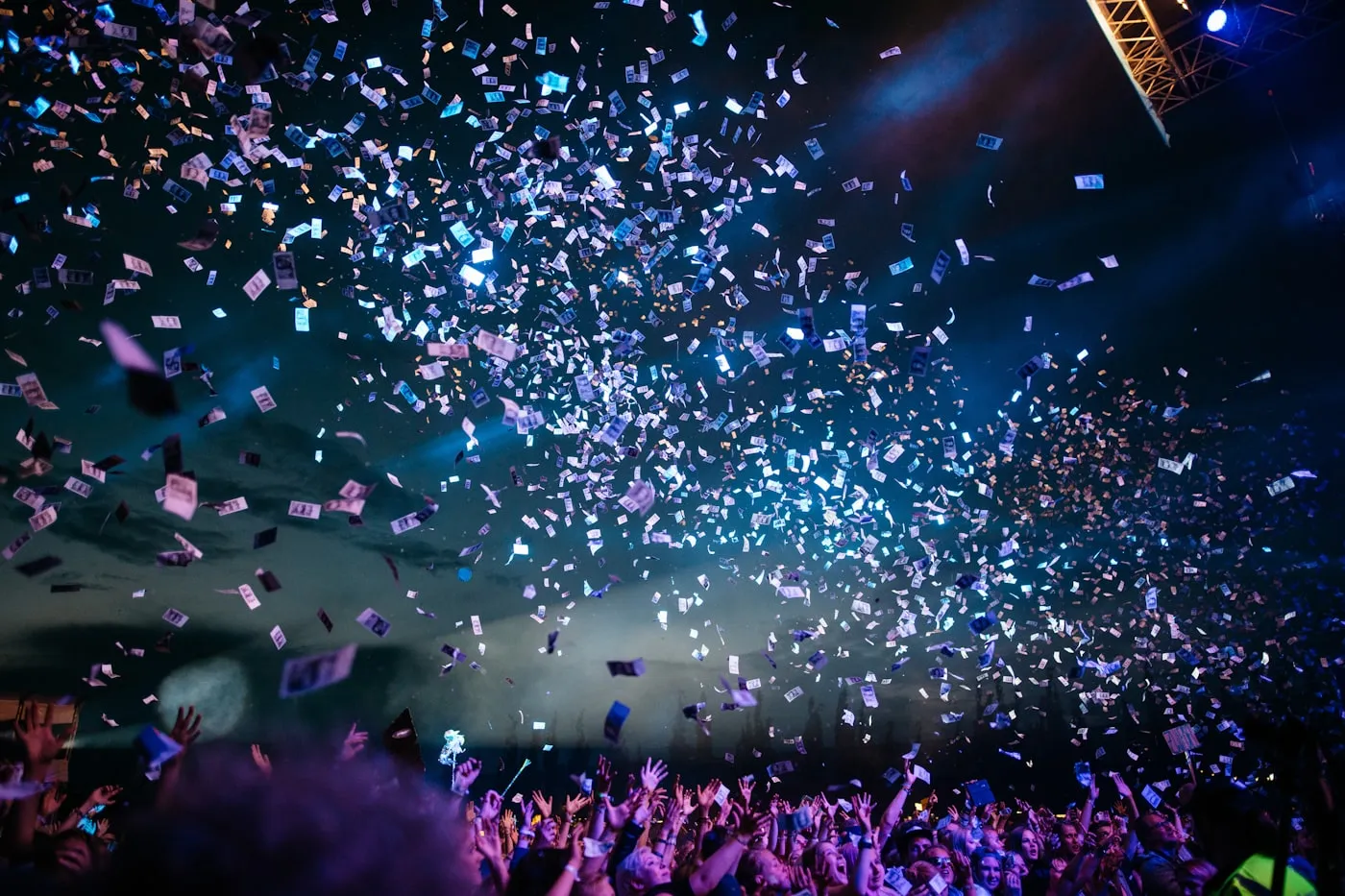 A live event with dramatic stage lighting over a gathered crowd.