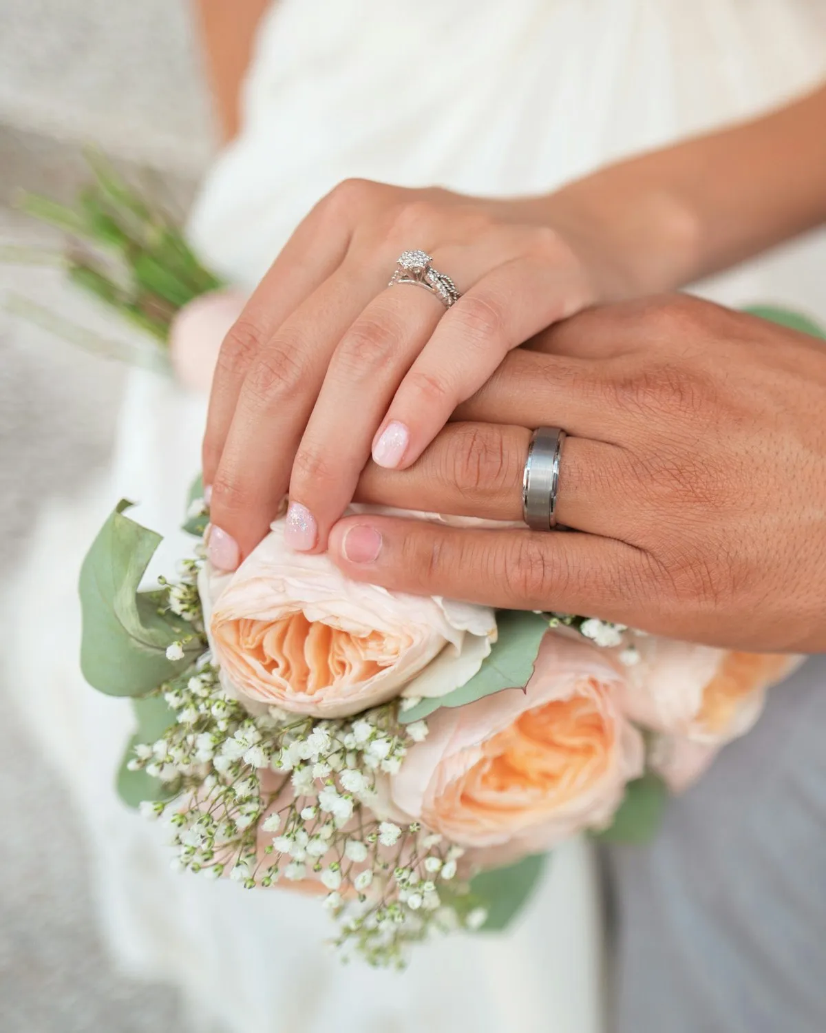 A bride during the ceremony, holding a bouquet, captured in candid daylight.